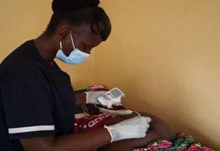 A midwife attends to a pregnant woman in Liberia